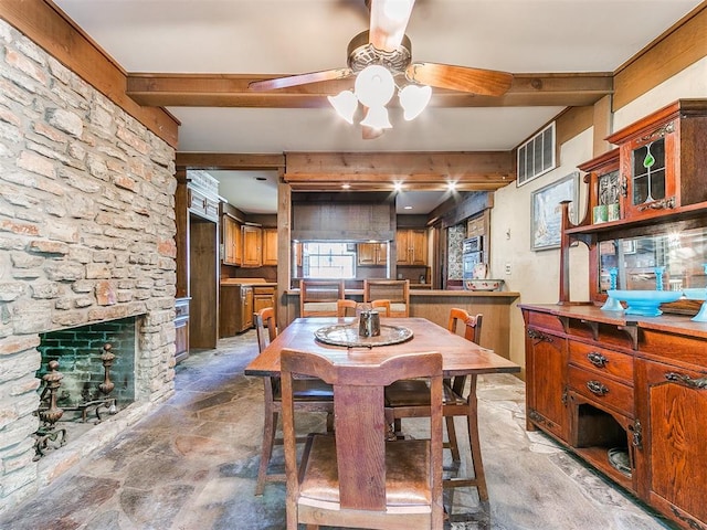 dining space featuring a fireplace, beam ceiling, and ceiling fan