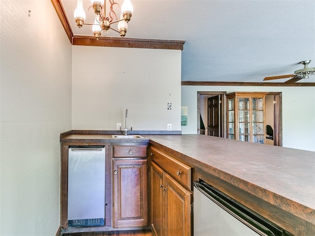 kitchen featuring kitchen peninsula, ceiling fan with notable chandelier, crown molding, sink, and pendant lighting