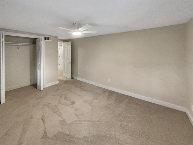 unfurnished bedroom featuring light carpet, a closet, and ceiling fan