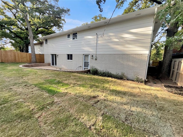 rear view of property with a patio and a lawn