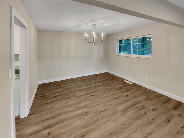 unfurnished dining area with wood-type flooring and a notable chandelier