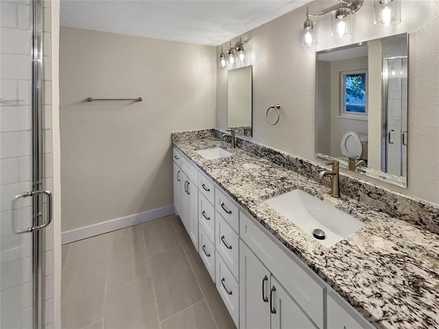 bathroom featuring tile patterned floors, vanity, a shower with shower door, and toilet