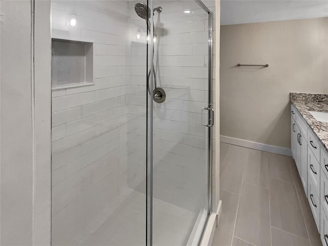 bathroom featuring tile patterned floors, vanity, and a shower with door