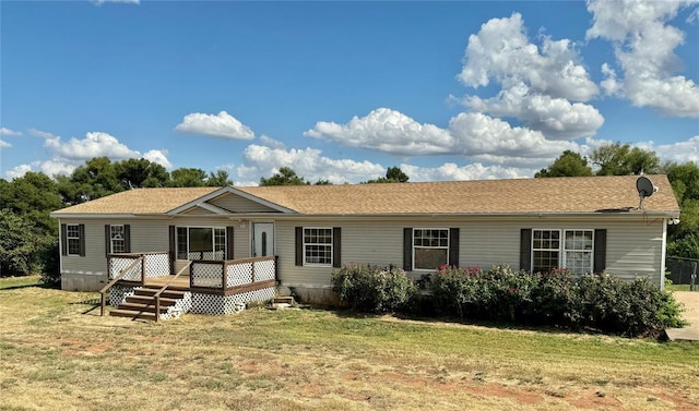 view of front of home with a deck and a front lawn