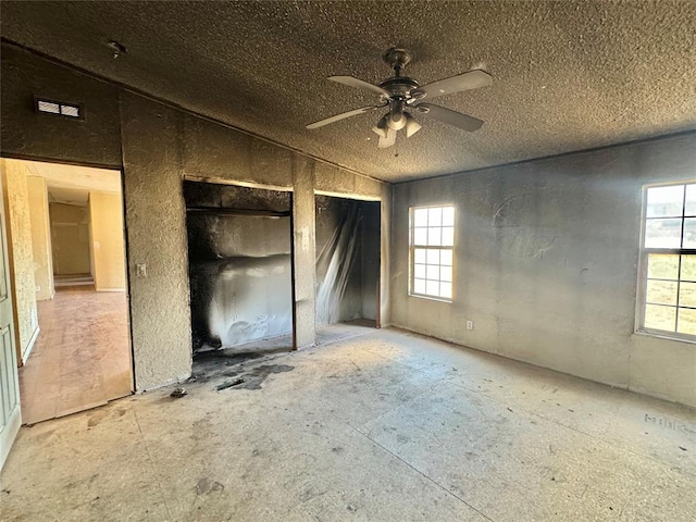 unfurnished bedroom featuring ceiling fan and a textured ceiling