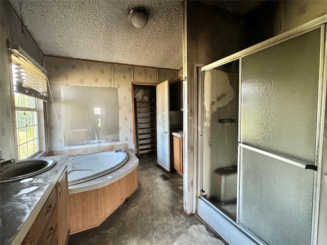 bathroom with vanity, a textured ceiling, and plus walk in shower