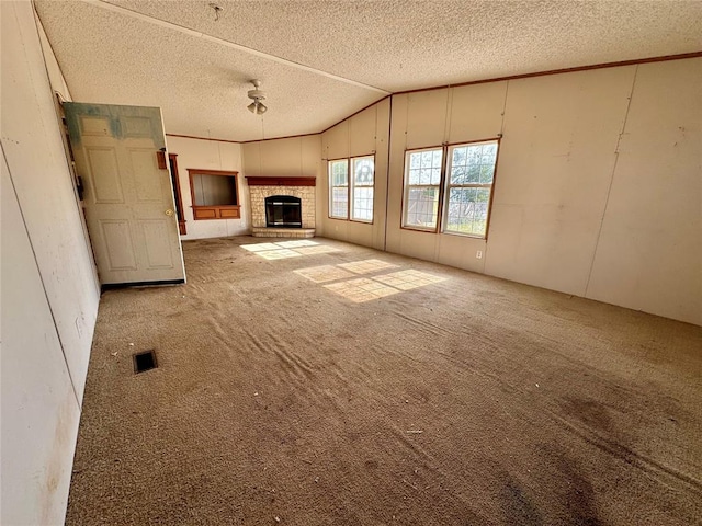 unfurnished living room featuring carpet flooring, lofted ceiling, and a textured ceiling