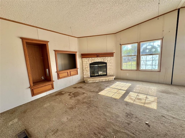 unfurnished living room with a stone fireplace, carpet floors, and a textured ceiling