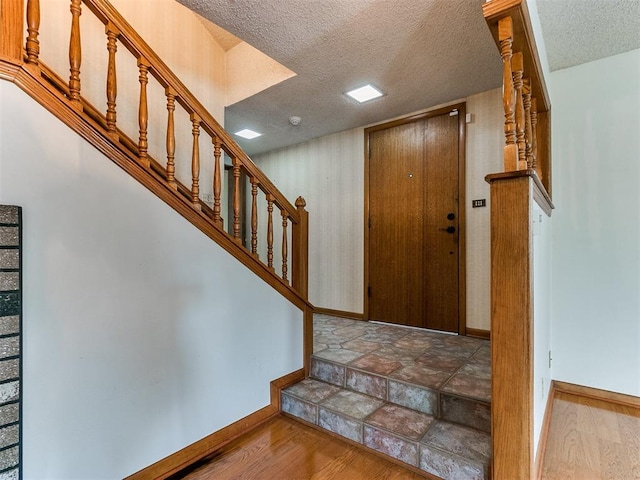 entryway featuring hardwood / wood-style floors and a textured ceiling