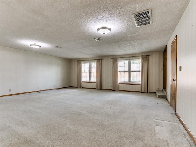 unfurnished room featuring light carpet and a textured ceiling