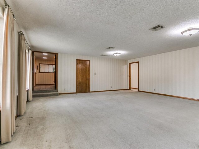 carpeted spare room with a textured ceiling