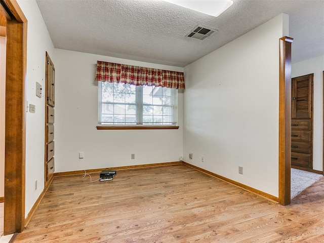 unfurnished bedroom with light hardwood / wood-style floors and a textured ceiling