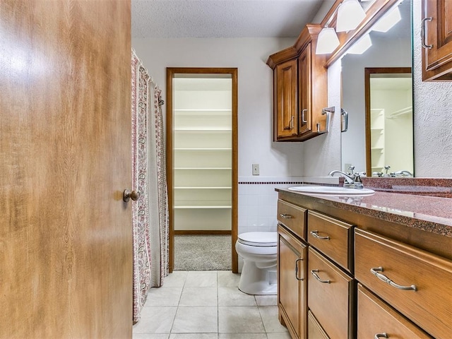 bathroom featuring tile patterned floors, vanity, toilet, and a textured ceiling