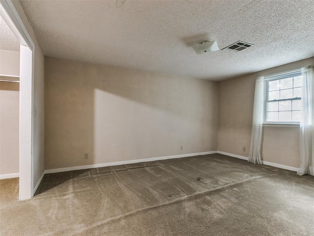 carpeted spare room with a textured ceiling