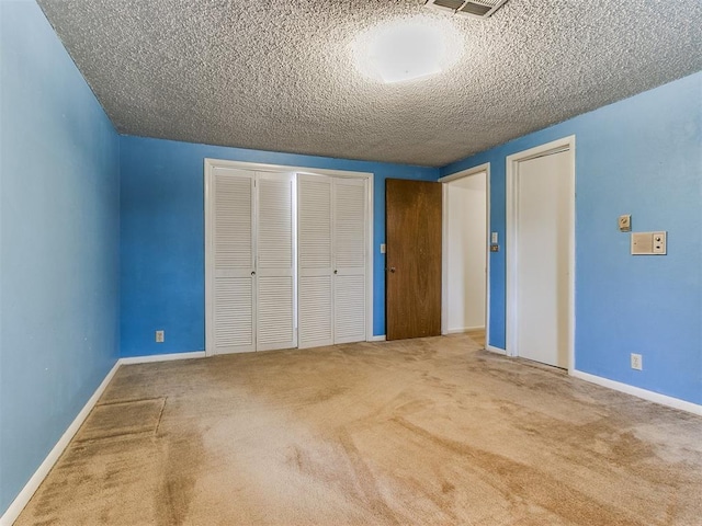 unfurnished bedroom with carpet and a textured ceiling