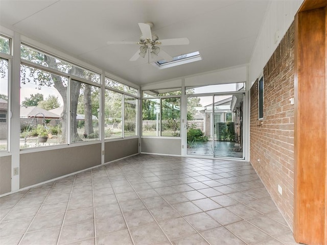 unfurnished sunroom featuring ceiling fan, a healthy amount of sunlight, and lofted ceiling with skylight