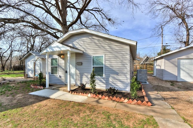 bungalow-style house with an outbuilding, a garage, and central air condition unit