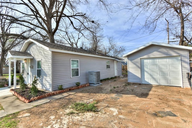 view of property exterior featuring an outbuilding, central AC, and a garage