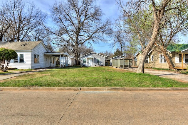 view of front of home with a front yard and an outdoor structure