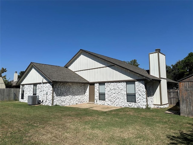 back of house featuring a lawn and cooling unit