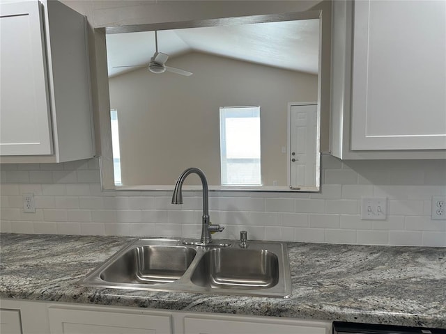 interior details featuring ceiling fan, sink, white cabinetry, and backsplash