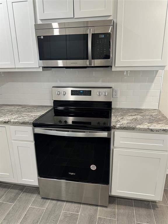 kitchen featuring light hardwood / wood-style flooring, white cabinets, and stainless steel appliances