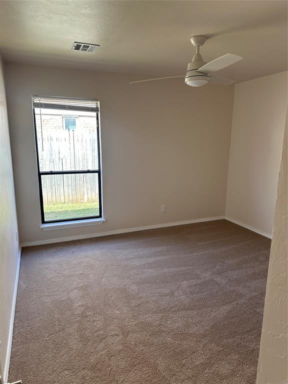 carpeted spare room featuring ceiling fan