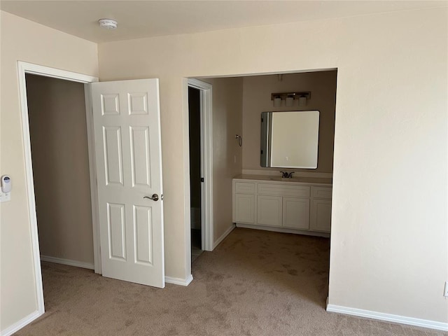 corridor with light colored carpet and sink