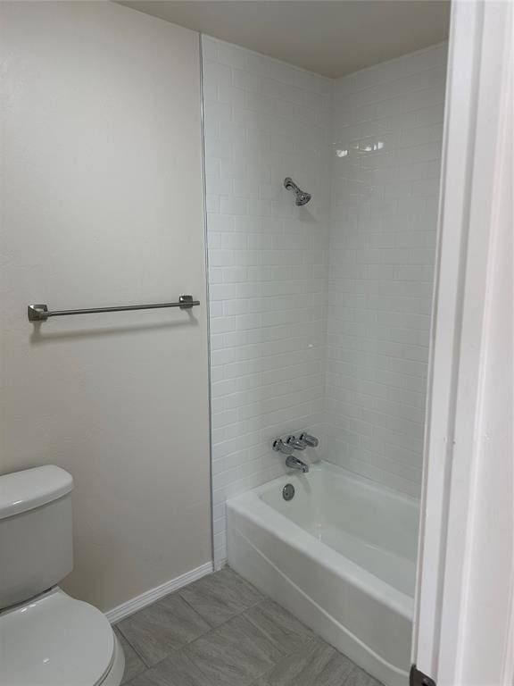 bathroom featuring toilet and tiled shower / bath