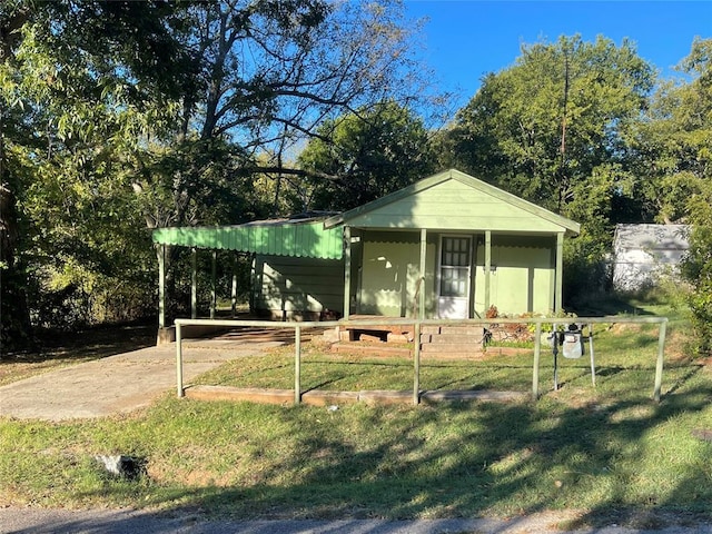 bungalow-style home featuring a front yard, a porch, and a carport