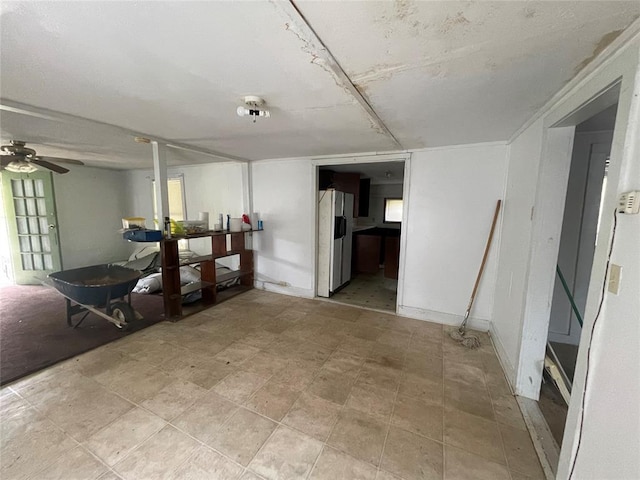 basement with ceiling fan and fridge with ice dispenser