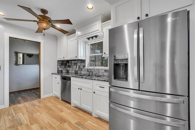 kitchen with dark stone countertops, sink, white cabinetry, and stainless steel appliances