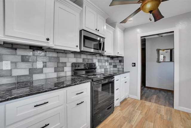 kitchen featuring tasteful backsplash, electric range, dark stone countertops, white cabinets, and light hardwood / wood-style floors