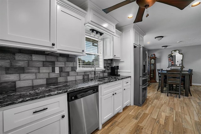 kitchen with light wood-type flooring, stainless steel appliances, white cabinetry, and sink