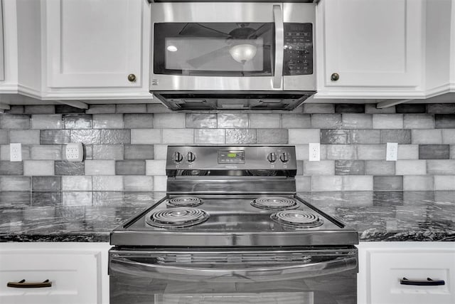 kitchen with backsplash, white cabinetry, dark stone counters, and appliances with stainless steel finishes