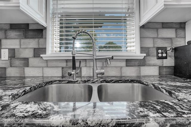 details with crown molding, white cabinetry, sink, and dark stone counters