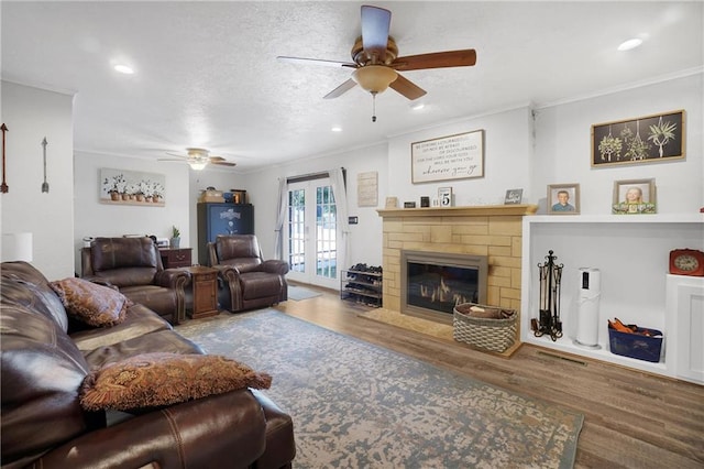 living room with crown molding, hardwood / wood-style floors, ceiling fan, and a textured ceiling