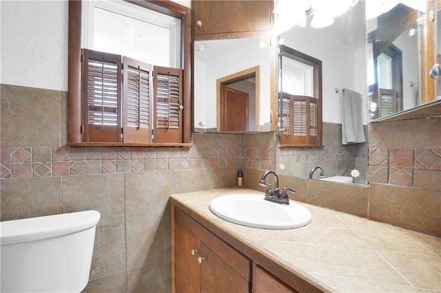 bathroom with vanity, toilet, and decorative backsplash