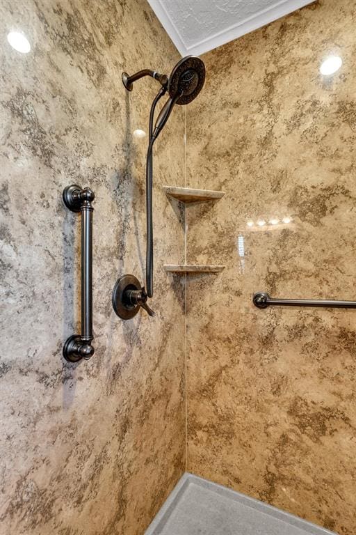 interior details featuring ornamental molding and tiled shower