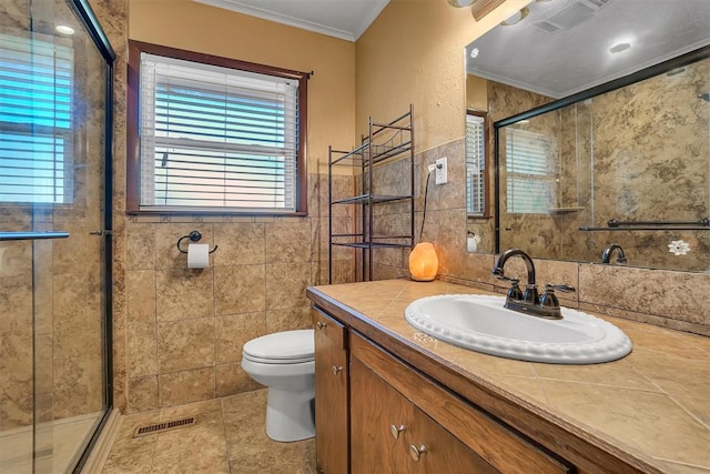 bathroom with crown molding, vanity, an enclosed shower, and toilet