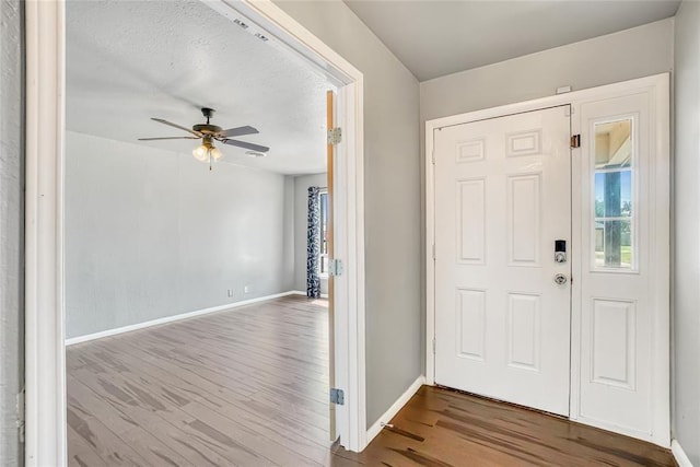 foyer entrance featuring ceiling fan, hardwood / wood-style floors, and a textured ceiling