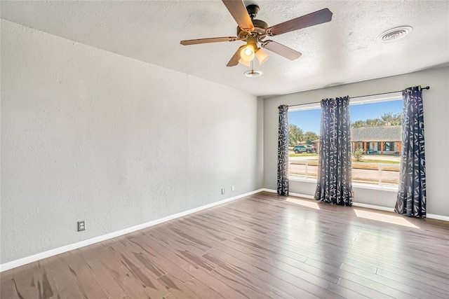 unfurnished room with hardwood / wood-style floors, a textured ceiling, and ceiling fan