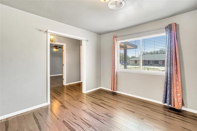 unfurnished room featuring wood-type flooring, a textured ceiling, and ceiling fan