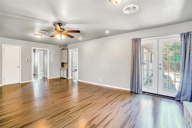 interior space with ceiling fan, french doors, a textured ceiling, and hardwood / wood-style flooring