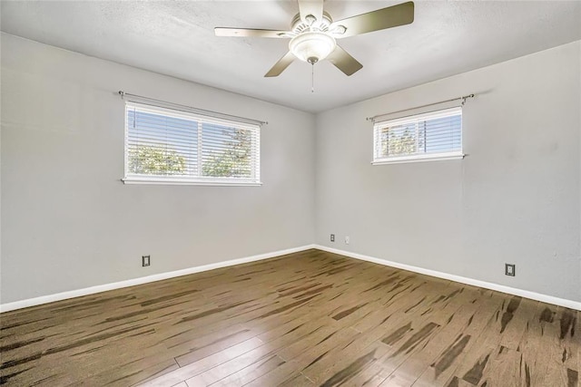 spare room featuring a wealth of natural light, ceiling fan, and wood-type flooring