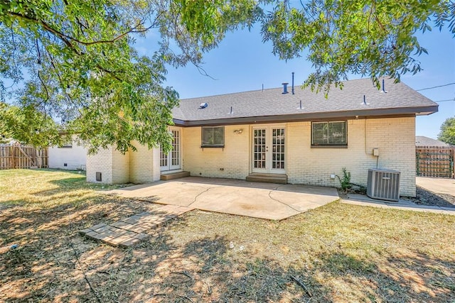 rear view of house featuring a lawn, central AC, french doors, and a patio