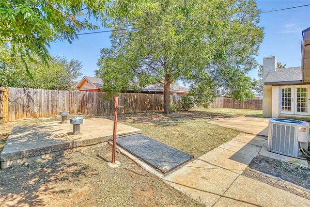 view of yard with central AC unit and a patio area