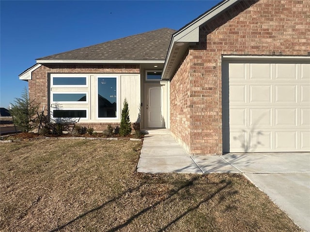 property entrance featuring a garage and a lawn