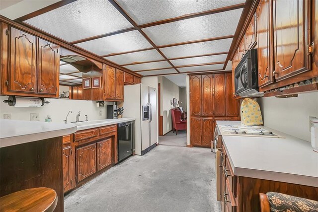 128 W Quail Dr, Cordell, OK 73632 - kitchen featuring black appliances, a sink, unfinished concrete floors, and light countertops