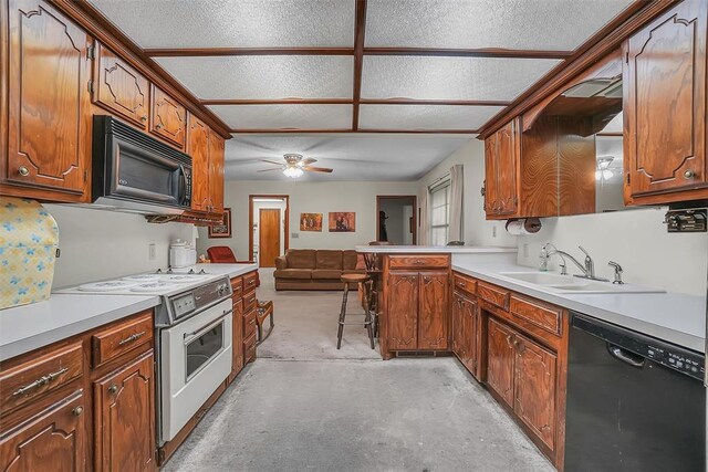 128 W Quail Dr, Cordell, OK 73632 - kitchen featuring black appliances, a sink, concrete floors, a peninsula, and open floor plan